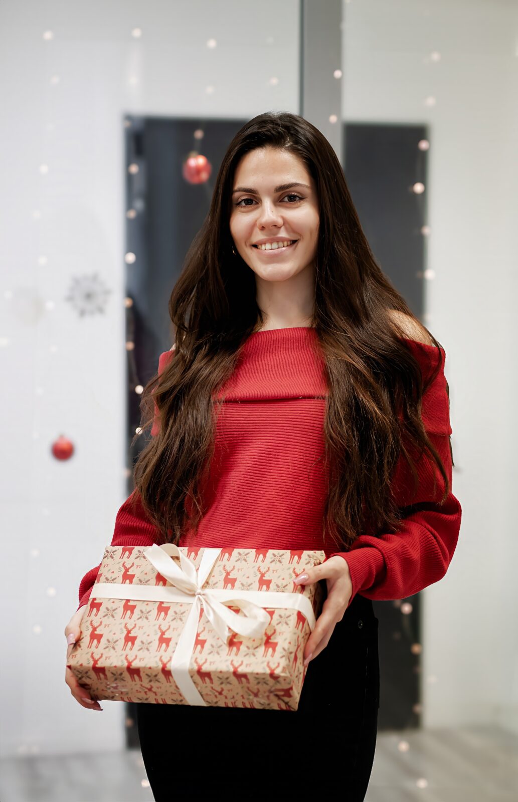 Specjalistka Facebook Ads trzymająca zapakowany prezent w biurze Social Elite