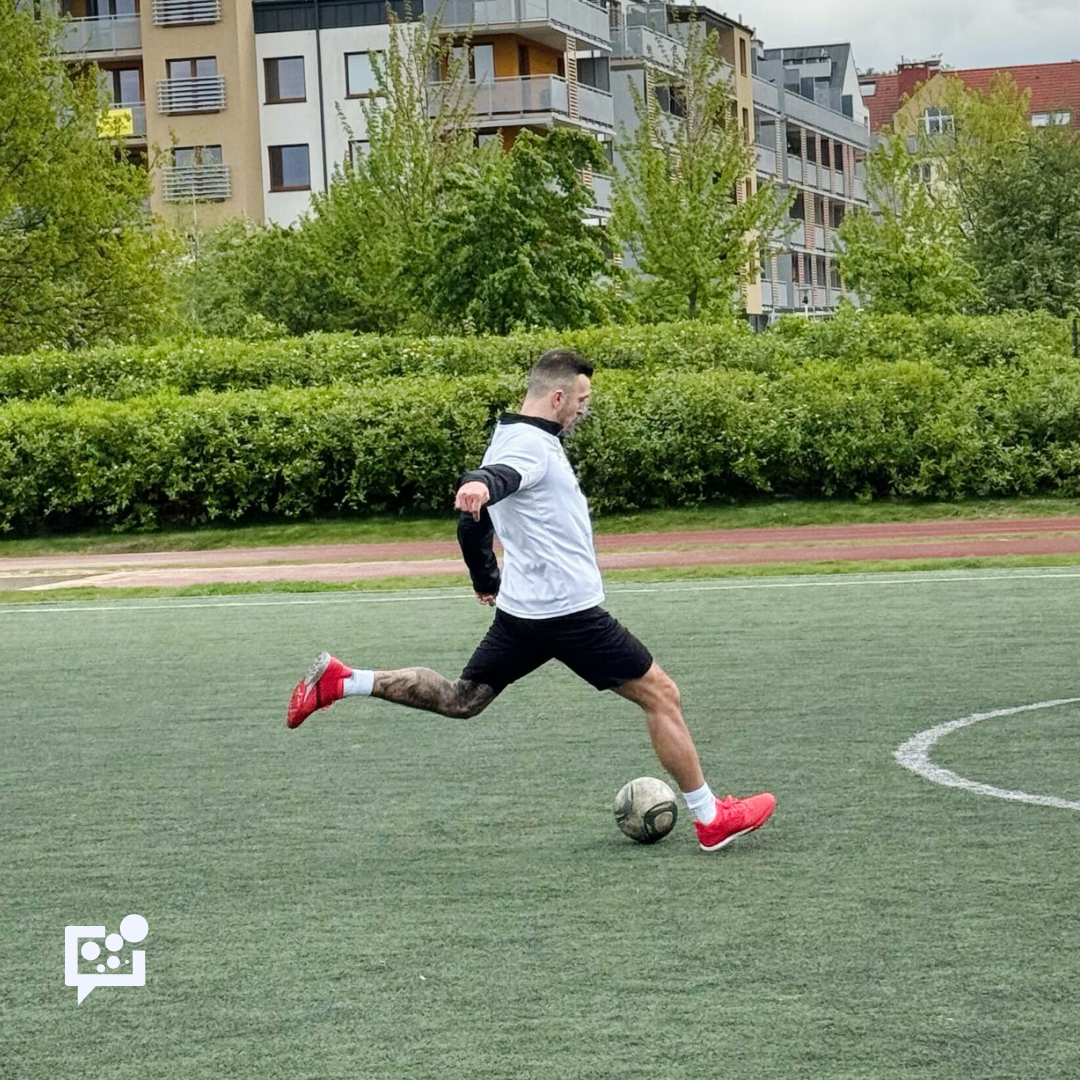 młody chłopak na boisku piłkarskim z piłką przy nodze