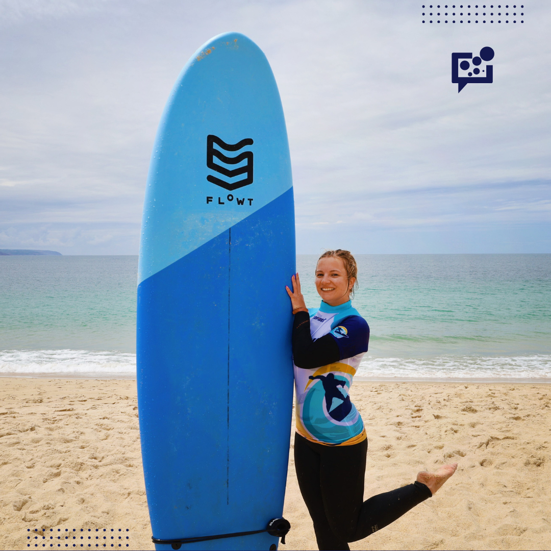 młoda dziewczyna stojąca przy desce surfingowej