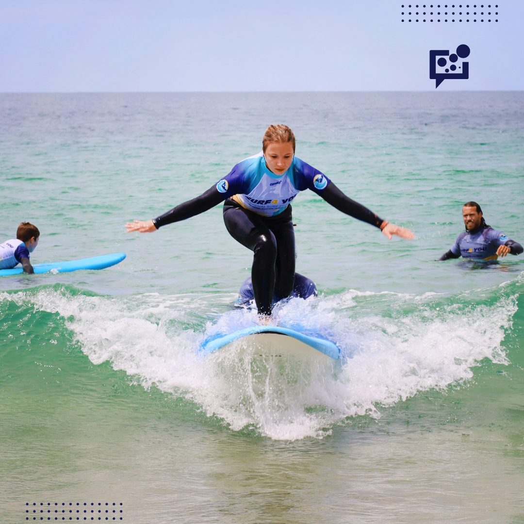 młoda dziewczyna surfująca na desce z rozłożonymi rękami